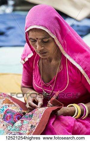 Stock Photograph - A Hindu Indian woman sits doing needlework, Fort Jaisalmer; Jaisalmer, Rajasthan, India. Fotosearch