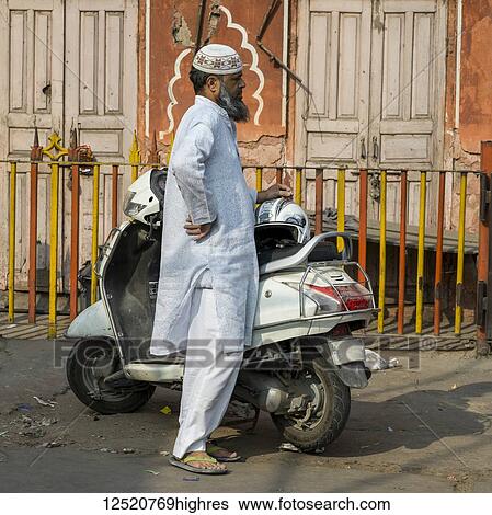A man in traditional Indian dress stands on the street beside his motorcycle; Jaipur, Rajasthan, India View Large Photo Image Stock Photograph - A man in traditional Indian dress stands on the street beside his motorcycle; Jaipur, Rajasthan, India. Fotosearch