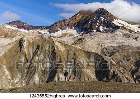 A man is dwarfed by the jagged, ash-covered Knife Creek Glaciers and Trident Volcano in the Valley of Ten Thousand Smokes in Katmai National Park; Alaska, United States of America View Large Photo Image Stock Photograph - A man is dwarfed by the jagged, ash-covered Knife Creek Glaciers and Trident Volcano in the Valley of Ten Thousand Smokes in Katmai National Park; Alaska, United States of America. Fotosearch