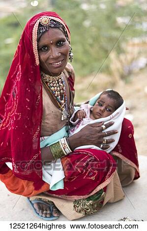 Stock Photograph - A mother holding her baby girl; Jaisalmer, Rajasthan, India. Fotosearch
