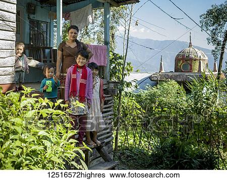 Stock Photograph - A mother with four children standing on the steps of their home near the Glenburn Tea Estate; West Bengal, India. Fotosearch