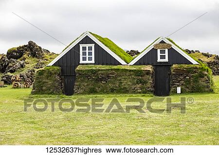 Stock Photograph - A pair of historic turf houses at a tourist attraction in Western Iceland; Iceland. Fotosearch