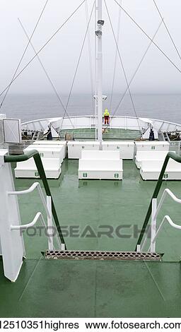 A person stands at the stern of a ship looking out to sea and the horizon shrouded with cloud; Prince Edward Island, Canada View Large Photo Image Stock Photograph - A person stands at the stern of a ship looking out to sea and the horizon shrouded with cloud; Prince Edward Island, Canada. Fotosearch