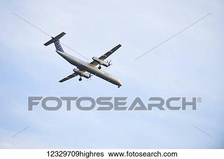 A Plane Flying Overhead From Billy Bishop Toronto City Airport; Toronto, Ontario, Canada View Large Photo Image Stock Photograph - A Plane Flying Overhead From Billy Bishop Toronto City Airport; Toronto, Ontario, Canada. Fotosearch