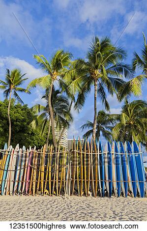 Stock Photograph - A rack of colourful surfboards lined up on Waikiki Beach; Honolulu, Oahu, Hawaii, United States of America. Fotosearch