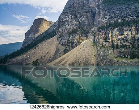 A red canoe in Moraine Lake with a cliff of the Canadian Rocky Mountains along the shoreline; Lake Louise, Alberta, Canada View Large Photo Image Stock Photograph - A red canoe in Moraine Lake with a cliff of the Canadian Rocky Mountains along the shoreline; Lake Louise, Alberta, Canada. Fotosearch