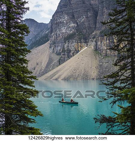 A red canoe in Moraine Lake with a cliff of the Canadian Rocky Mountains along the shoreline; Lake Louise, Alberta, Canada View Large Photo Image Stock Photograph - A red canoe in Moraine Lake with a cliff of the Canadian Rocky Mountains along the shoreline; Lake Louise, Alberta, Canada. Fotosearch