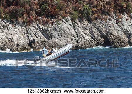 Stock Photograph - A speedboat in the Bay of Kotor with the bow in the air as it cruises down the coastline; Monte. Fotosearch