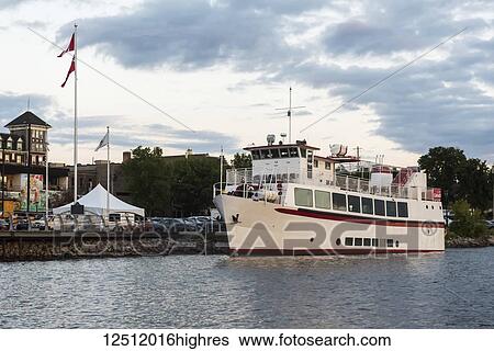 Stock Photograph - A tour boat moored along the shoreline of Lake of the Woods at sunset; Kenora, Ontario, Canada. Fotosearch