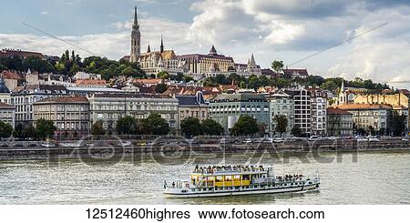 Stock Photograph - A tour boat travels down the Danube River past Budapest; Budapest, Budapest, Hungary. Fotosearch