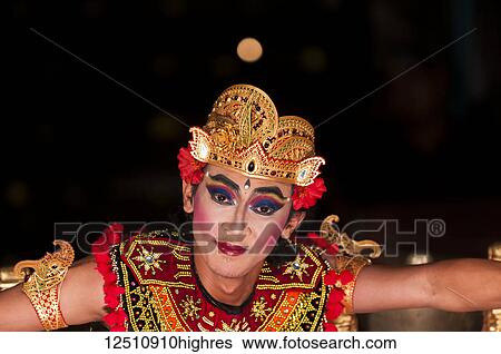 Stock Photograph - A traditional Balinese dancer poses at the end of a dance; Ubud, Bali, Indonesia. Fotosearch
