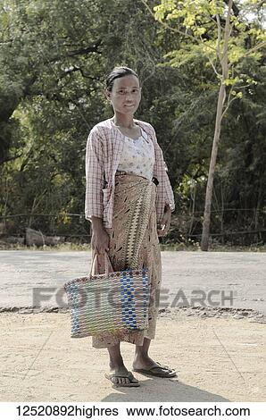 A woman standing with a woven bag going to market; Bagan, Myanmar View Large Photo Image Stock Photograph - A woman standing with a woven bag going to market; Bagan, Myanmar. Fotosearch