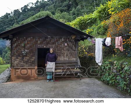 Stock Photograph - A woman stands outside her home in Radhu Khandu village; Sikkim, India. Fotosearch