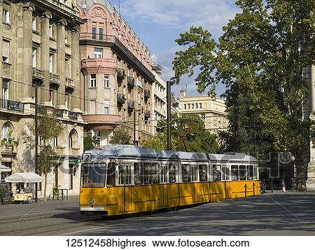 Stock Photograph - A yellow tram runs on a track through the streets; Budapest, Budapest, Hungary. Fotosearch