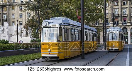 A yellow tram runs on a track through the streets; Budapest, Budapest, Hungary View Large Photo Image Stock Photograph - A yellow tram runs on a track through the streets; Budapest, Budapest, Hungary. Fotosearch