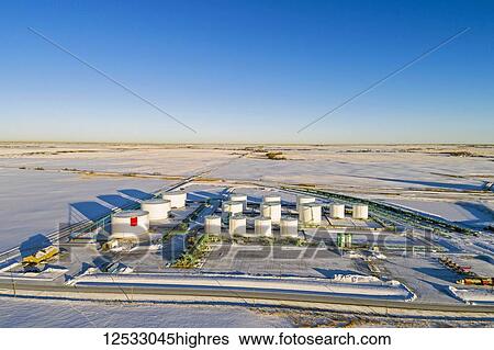 Aerial view of large white metal oil storage tanks in a snow-covered field with blue sky, South of Calgary; Alberta, Canada View Large Photo Image Stock Photograph - Aerial view of large white metal oil storage tanks in a snow-covered field with blue sky, South of Calgary; Alberta, Canada. Fotosearch