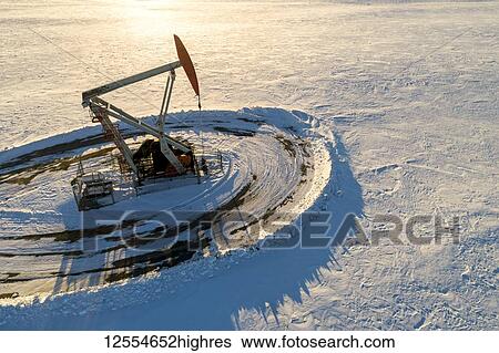 Aerial view of pumpjack in snow-covered field at sunrise; Longview, Alberta, Canada View Large Photo Image Stock Photograph - Aerial view of pumpjack in snow-covered field at sunrise; Longview, Alberta, Canada. Fotosearch