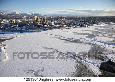 Aerial view of snow covering the the sea ice on the frozen shores of downtown Anchorage, the Chugach Mountains in the background beyond the office buildings and hotels in downtown Anchorage in winter, South-central Alaska; Anchorage, Alaska, United... View Large Photo Image Stock Photograph - Aerial view of snow covering the the sea ice on the frozen shores of downtown Anchorage, the Chugach Mountains in the background beyond the office buildings and hotels in downtown Anchorage in winter, South-central Alaska; Anchorage, Alaska, United.... Fotosearch