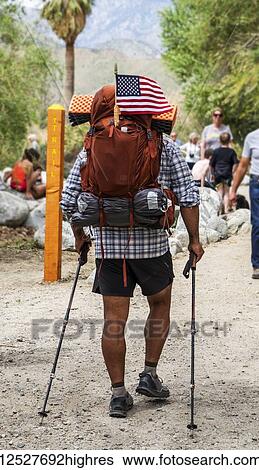 Stock Photograph - An American hiker travelling through Whitewater Preserve; Palm Springs, California, United States of America. Fotosearch
