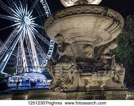 An illuminated ferries wheel and building with a carved stone statue in the foreground at nighttime; Budapest, Budapest, Hungary View Large Photo Image Stock Photograph - An illuminated ferries wheel and building with a carved stone statue in the foreground at nighttime; Budapest, Budapest, Hungary. Fotosearch