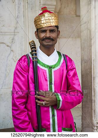 Stock Photograph - An Indian man in colourful traditional Indian clothing at City Palace; Jaipur, Rajasthan, India. Fotosearch