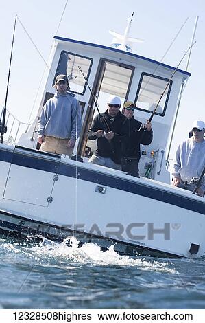 Stock Photograph - Angler reeling in a halibut, Kachemak Bay, South-central Alaska; Alaska, United States of America. Fotosearch
