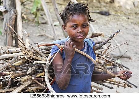 Stock Photograph - Ari girl carrying bundle of brushwood; Jinka, Southern Nations Nationalities and Peoples' Region, Ethiopia. Fotosearch