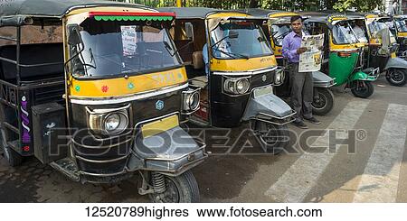 Auto rickshaws parked in a row along a street; Jaipur, Rajasthan, India View Large Photo Image Stock Photograph - Auto rickshaws parked in a row along a street; Jaipur, Rajasthan, India. Fotosearch