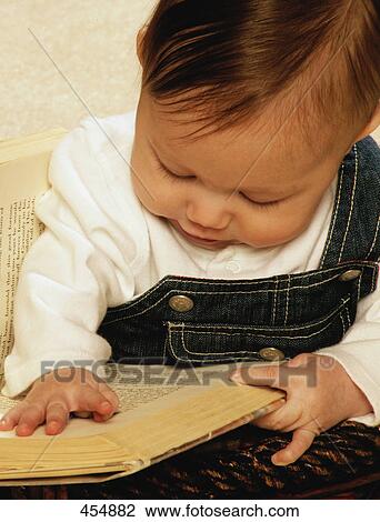 Stock Image - Baby reading a book. Fotosearch