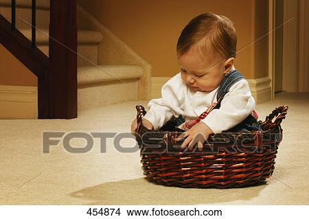 Picture - Baby sitting in a basket. Fotosearch