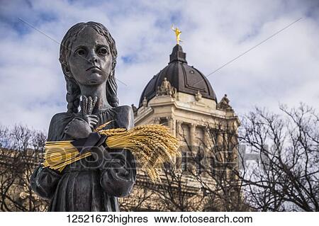 Stock Photograph - Bitter Memories of Childhood is a memorial statue on the Manitoba Legislative Grounds which pays tribute to the 1932-1933 Ukrainian Famine and Genocide under Soviet ruler Joseph Stalin. The Legislative Building and the Golden Boy are seen in the.... Fotosearch