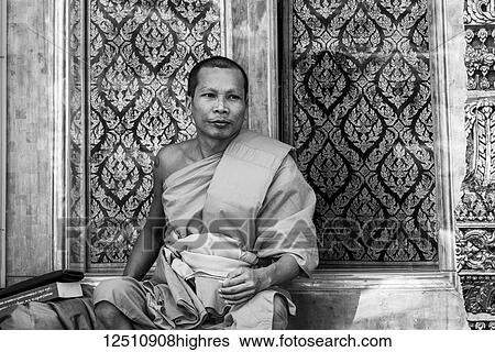 Stock Photograph - Black and white image of a monk resting outside a temple; Bangkok, Thailand. Fotosearch