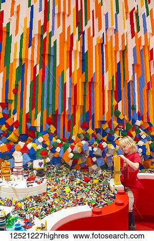 Stock Photograph - Boy building Lego tower in the Red Zone of the Lego House; Billund, Denmark. Fotosearch