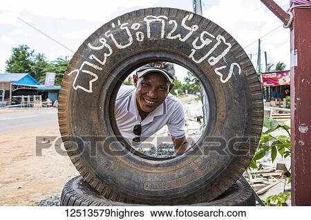 Cambodian man posing inside a tire at a tire repair shop; Sra'aem, Preah Vihear, Cambodia View Large Photo Image Stock Photograph - Cambodian man posing inside a tire at a tire repair shop; Sra'aem, Preah Vihear, Cambodia. Fotosearch
