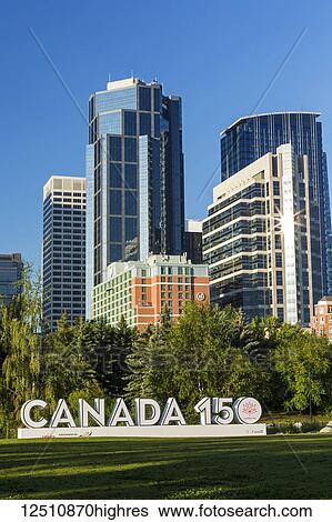 Canada 150 signage in city park with Calgary building towers in background with blue sky; Calgary, Alberta, Canada View Large Photo Image Stock Photograph - Canada 150 signage in city park with Calgary building towers in background with blue sky; Calgary, Alberta, Canada. Fotosearch