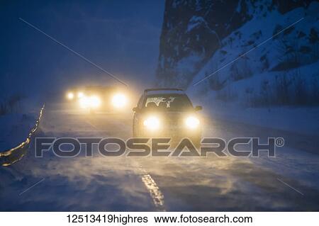 Car headlights from traffic illuminate the blowing snow on the Seward Highway during a dark winter night, Kenai Peninsula, Turnagain Arm, South-central Alaska; Alaska, United States of America View Large Photo Image Stock Photograph - Car headlights from traffic illuminate the blowing snow on the Seward Highway during a dark winter night, Kenai Peninsula, Turnagain Arm, South-central Alaska; Alaska, United States of America. Fotosearch