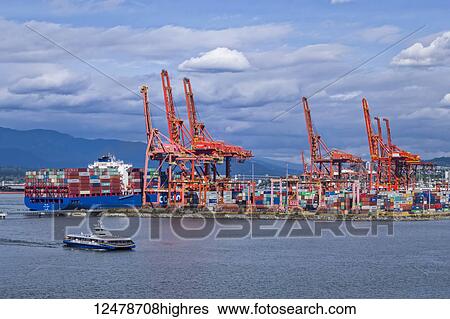 Stock Photograph - Cargo shipping port in the harbour of Vancouver with car ferry crossing; Vancouver, British Columbia, Canada. Fotosearch