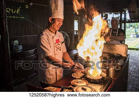 Stock Photograph - Chef cooking a Vietnamese pancake during a cooking class; Hoi An, Quang Nam, Vietnam. Fotosearch