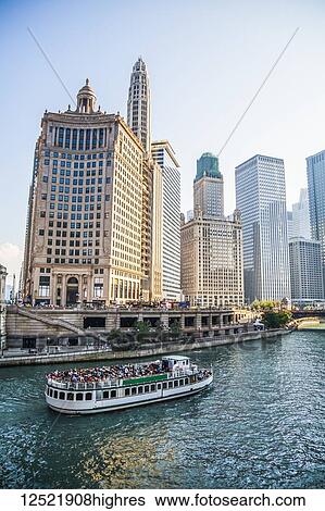 Stock Photograph - Chicago architecture lining the river with a tour boat; Chicago, Illinois, United States of America. Fotosearch