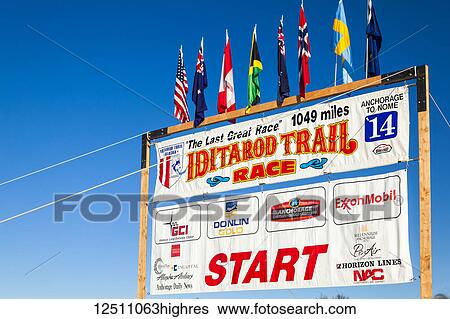 Stock Photograph - Close-up of Iditarod Trail Race 2014 start sign against blue sky, South-central Alaska in winter; Willow, Alaska, United States of America. Fotosearch