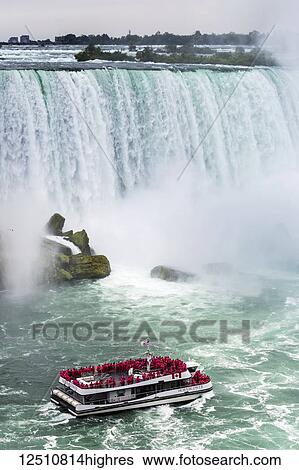 Stock Photograph - Close-up of Niagara Falls with tourist boat going towards the falls; Niagara Falls, Ontario, Canada. Fotosearch