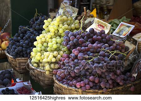 Stock Photograph - Close-up of three baskets of different colour grapes in market; Florence, Tuscany, Italy. Fotosearch