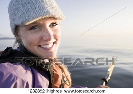 Stock Photograph - Close-up portrait of a young woman sea kayaking in Kachemak Bay, near Homer, South-central Alaska; Alaska, United States of America. Fotosearch