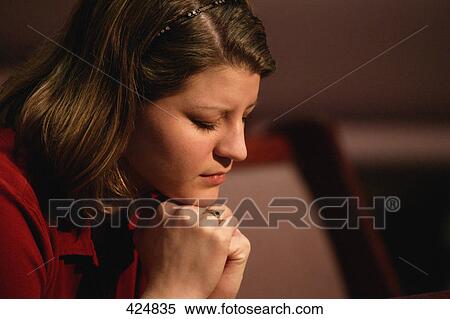 Stock Photography - Closeup of woman praying. Fotosearch