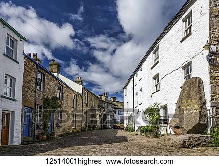 Stock Photograph - Cobbled street and birthplace of Adam Sedgwick, a British geologist and one of the founders of modern geology; Dent, Cumbria, England. Fotosearch