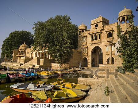 Stock Photograph - Colourful boats mooring along the shore of Gadsisar Lake; Jaisalmer, Rajasthan, India. Fotosearch