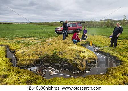 Stock Photograph - Cooking an egg in a net in a boiling spring; Kleppjarnsreykir, Iceland. Fotosearch