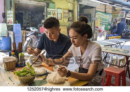 Stock Photograph - Couple enjoying a meal in the Old Quarter; Hanoi, Vietnam. Fotosearch