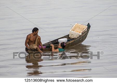 Stock Photograph - Couple fishing from a boat on the Tonle Sap; Siem Reap, Cambodia. Fotosearch