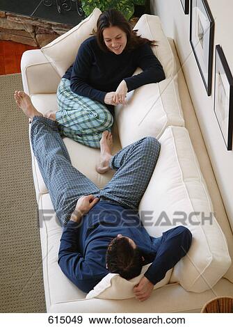 Couple relaxing on sofa View Large Photo Image Stock Photo - Couple relaxing on sofa. Fotosearch